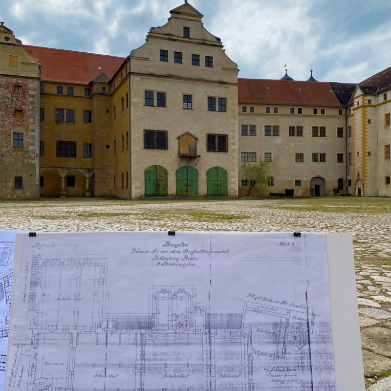 historische Baupläne vor Schlossfassade